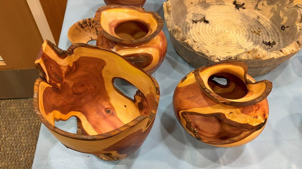 Three turned Juniper bowls with intricate and irregular shapes.