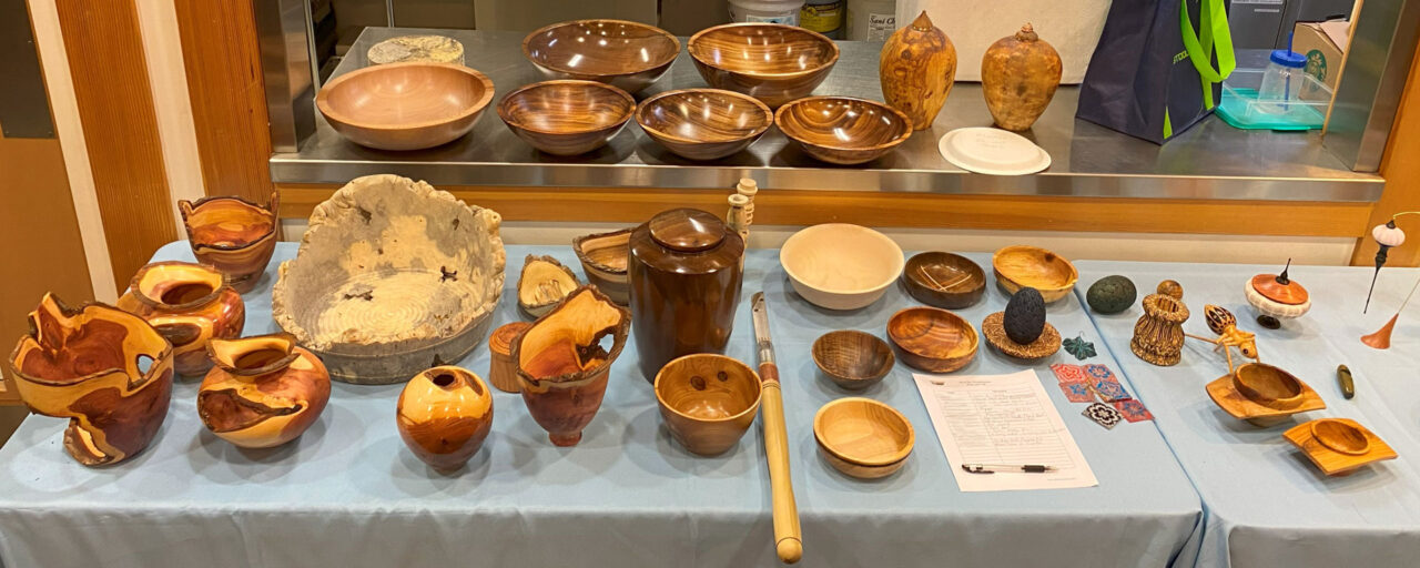 A table full of woodturning projects for Woodturners Newsletter: bowls, platters, tool handles, ornaments, urns, etc.