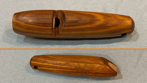 A turned whistle is shown from two sides. 3" long. Turned from unknown wood.