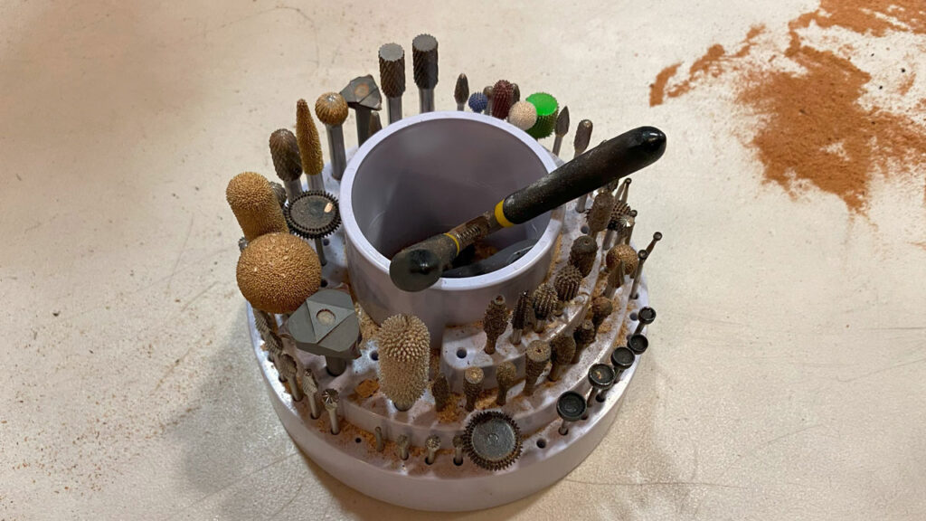 A stand with dozens of rotary burrs and power carving bits.