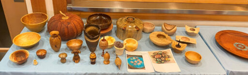 A table full of various woodturned items. Mostly bowls and vases.