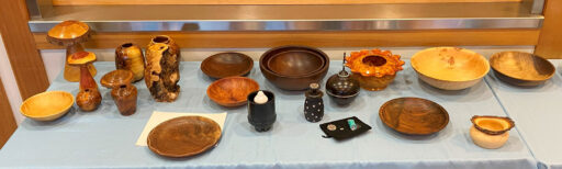 A table full of various woodturned items. Mostly bowls and vases.