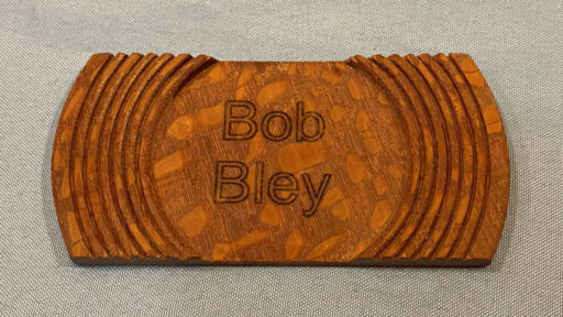 Turned badge with the name burned by a laser engraver.