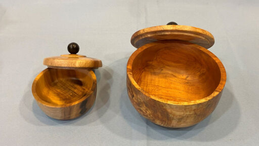 Two lidded boxes with a round finial on each lid.
