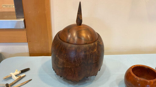 The live edge is at the bottom of the lidded bowl, turned from walnut.