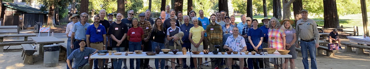 A group of people with a table full of woodturning projects. The photo of WBW and SVW members was taken for the woodturners' newsletter.