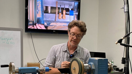 Mark Gardner shows how he sharpens his carving tools on a lathe.