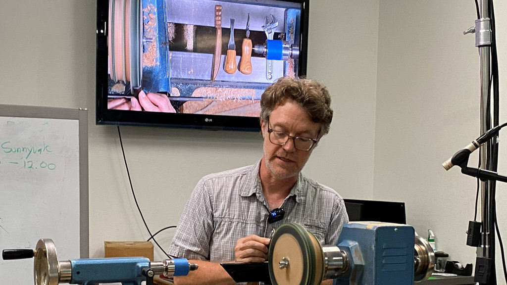 Mark Gardner shows how he sharpens his carving tools on a lathe.