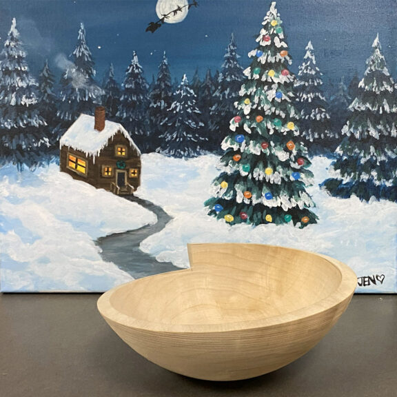A stepped-rim bowl. A painting of the house in a forest serves as the photo's background.