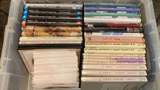 A box with dozens of woodturning DVDs.