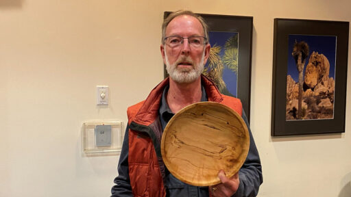 Dean Caudle is showing a large bowl he turned from a piece of firewood.