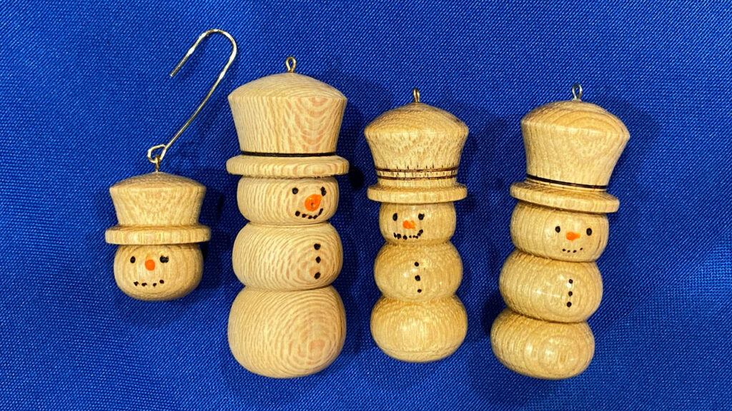 Four turned snowmen ornaments.