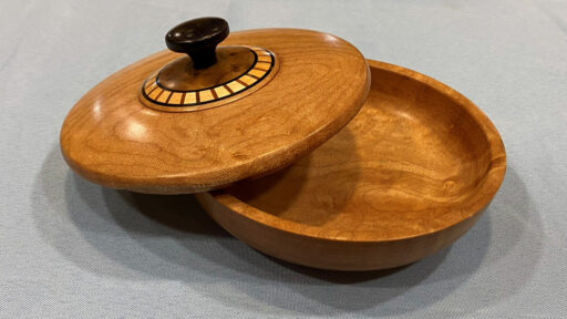 A lidded bowl turned from maple, walnut, and cherry. The image was prepared for the West Bay Woodturners newsletter.