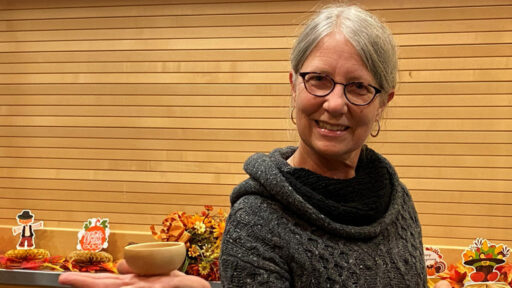 Kirsten is showing a bowl she turned from apricot wood.