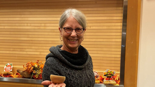 Kirsten is showing a bowl she turned from apricot wood.