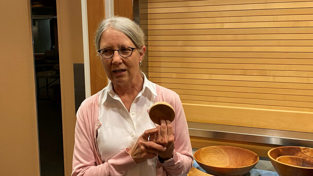 Kirsten shows a small bowl that she turned on a lathe.
