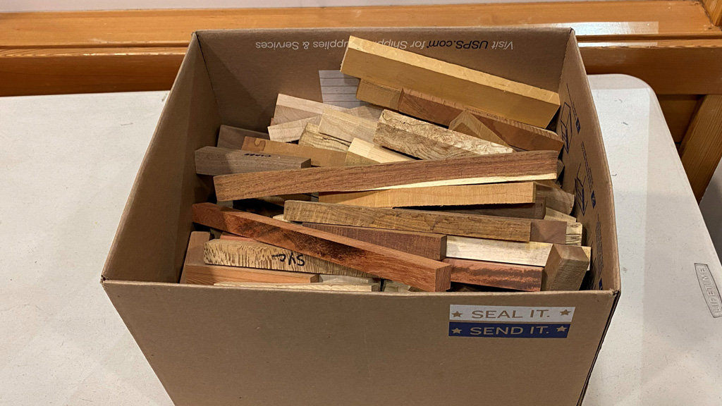 A large cardboard box with pen blanks for turning pens.