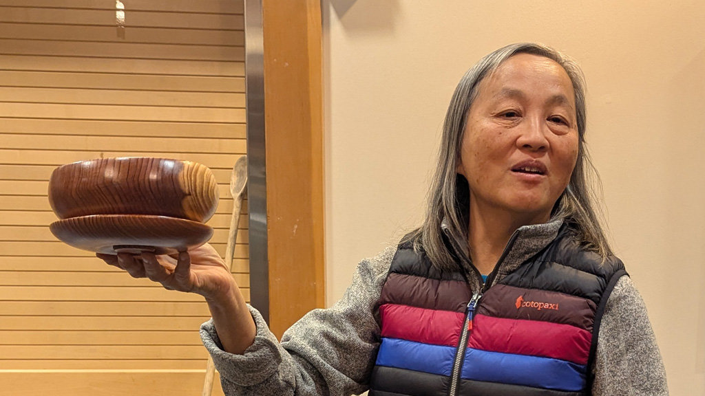 Alison is showing a calabash bowl with a lid that she recently turned.