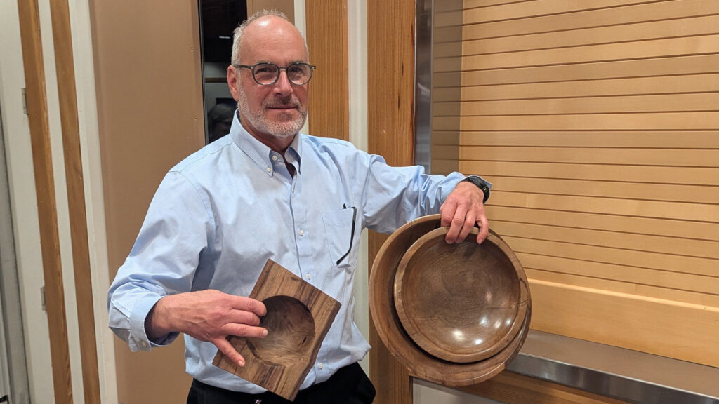 Daniel is showing large bowls that he turned from walnut.