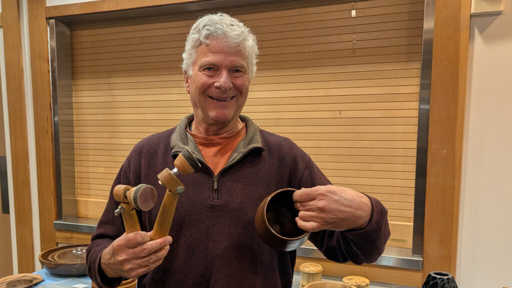Joe is showing a turned calabash bowl with sanding tools.