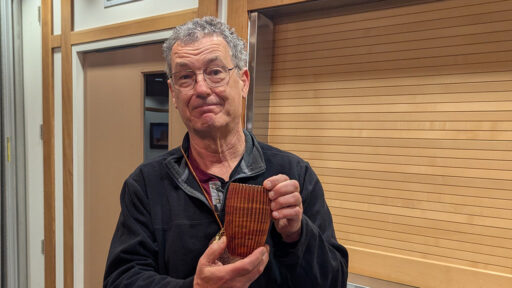 Jon Bishop is showing a fluted vessel that he turned on a lathe and used a router to add flutes.