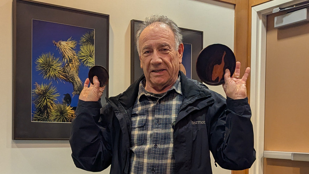 Jon is showing two small platters that he recently turned on a lathe.