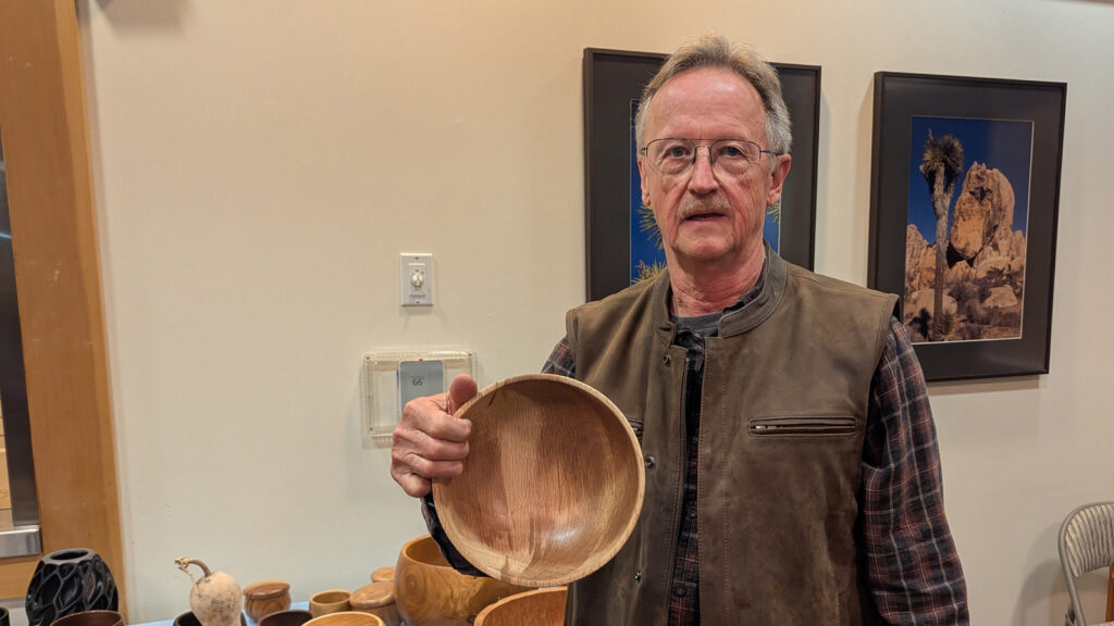 Tom Gaston is showing a catalpa calabash bowl that he recently turned on a lathe.
