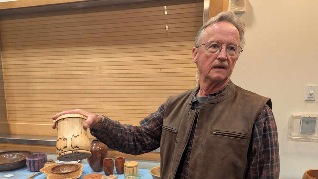 Tom Gaston is showing a lidded box he turned from a piece of spalted birch.