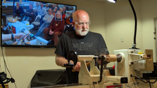 Vic is turning a sphere on a lathe, and the screen in the background shows the demo audience.
