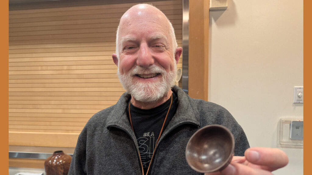 Vic is showing a small bowl that he turned on a lathe.