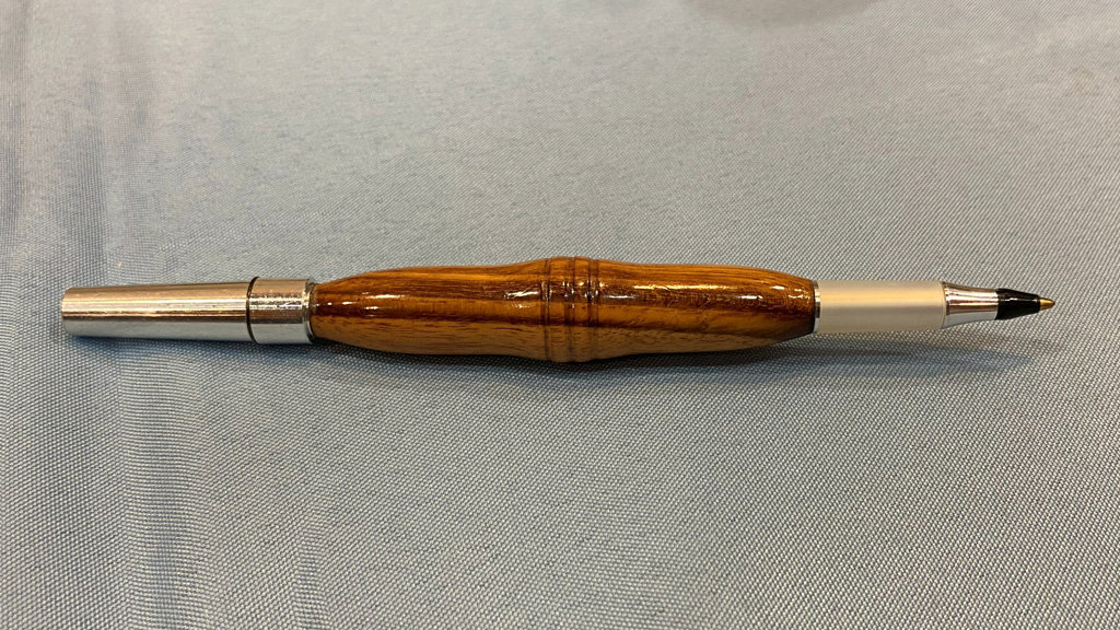 A turned pen with a uniquely shaped wooden part that Angle turned on a lathe.