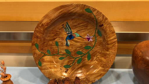 Gorgeous maple burl platter with a hummingbird and flower design inlaid with stone, turned by Bob Bley.