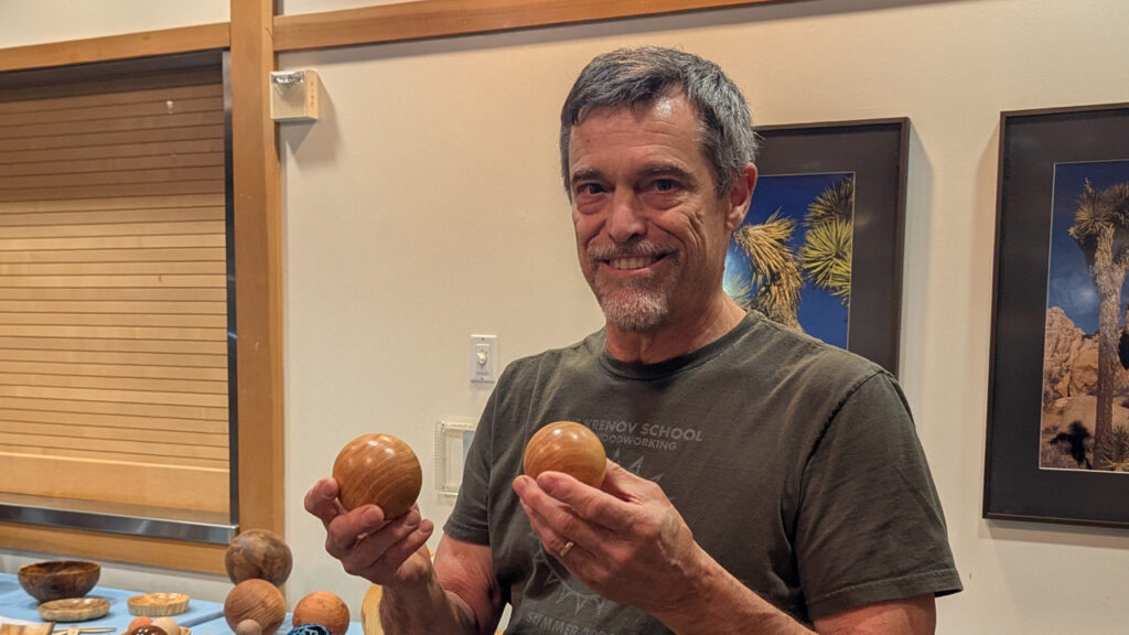Claude is showing two spheres that he turned on a lathe.