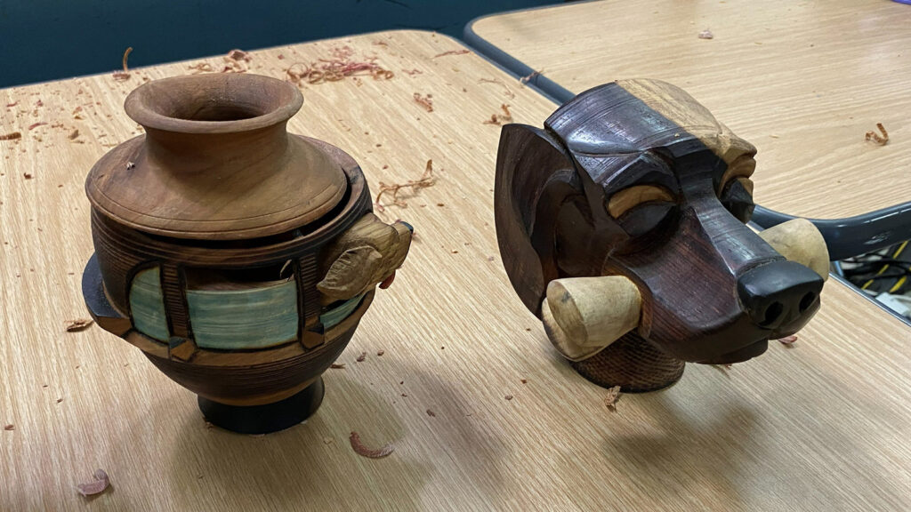 Turned and finished pieces by Derek Weidman: a hollow form and a dog with a bone.