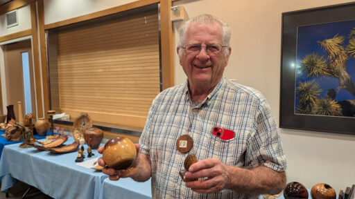 Ed is holding a sphere and an egg that he turned on a lathe.