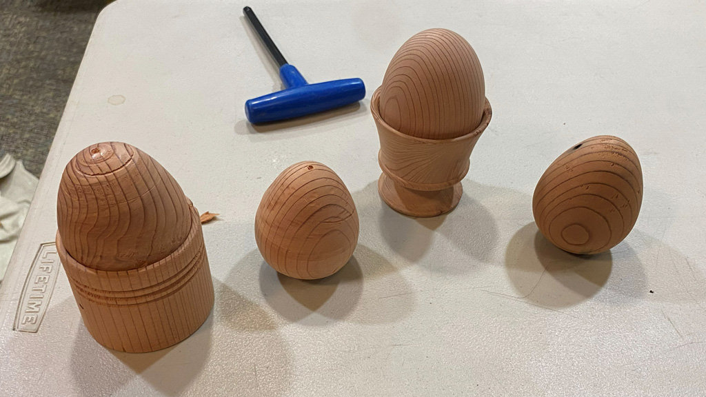 Four eggs turned from Redwood. Two of them are in egg holders.