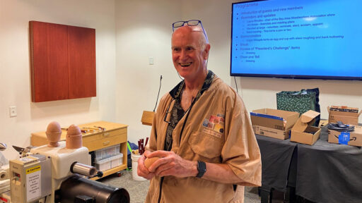 Edgar is showing eggs that he prepared for the woodturning demo.