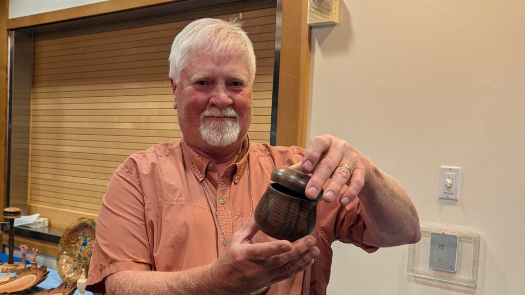 Jim is holding a lidded umeke bowl.