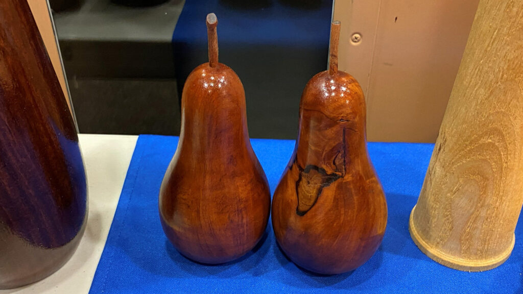 Two dark-colored pears turned from wood by Kelly Smith.