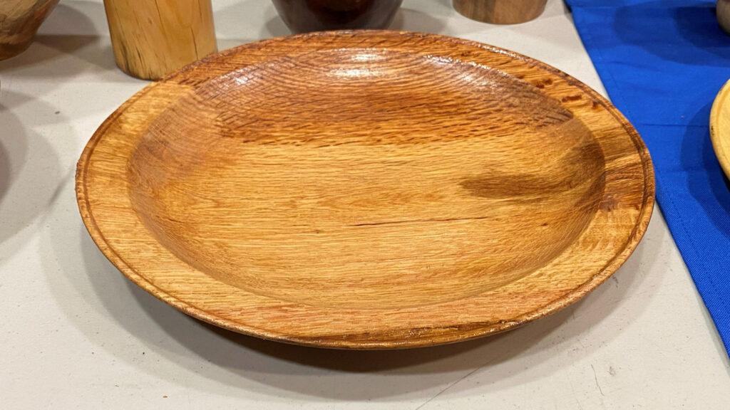 A large platter with a bid on its rim, hand-turned by Kelly Smith.