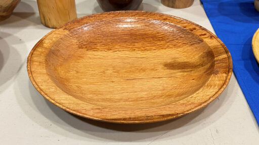 A large platter with a bid on its rim, hand-turned by Kelly Smith.