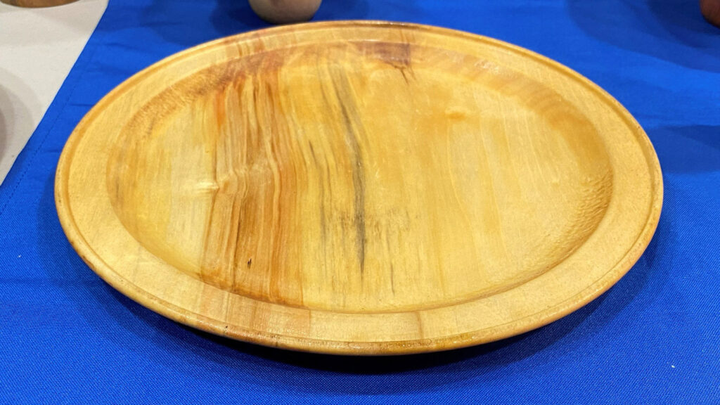 A large platter with a bid on its rim, hand-turned by Kelly Smith.