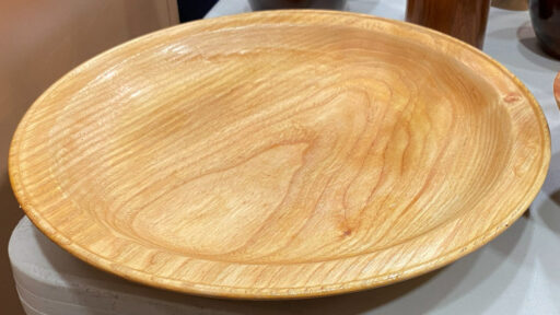 A large platter with a bid on its rim, hand-turned by Kelly Smith.