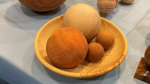 A wooden bowl with four wooden balls (spheres) that Kirsten turned on a lathe.
