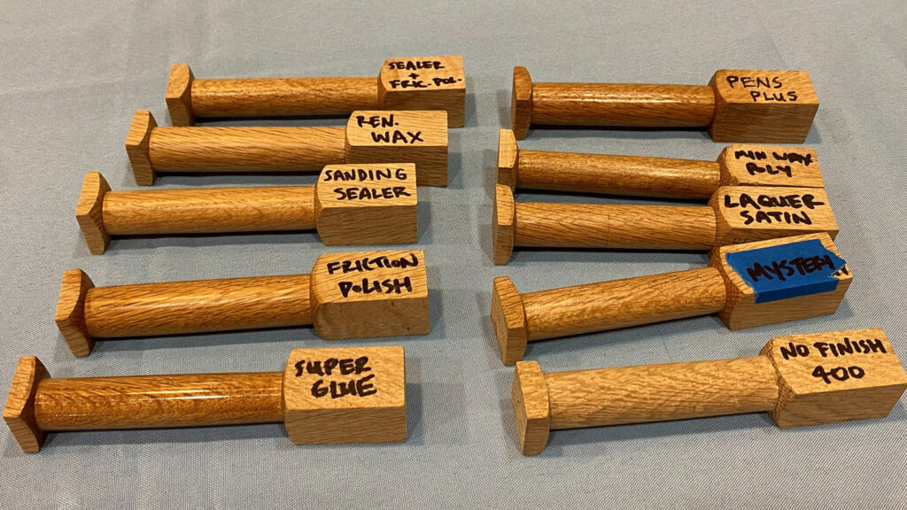 Ten partially turned wooden blanks show how different finishes look on them. The finishes include super glue, friction polish, lacquer, etc.