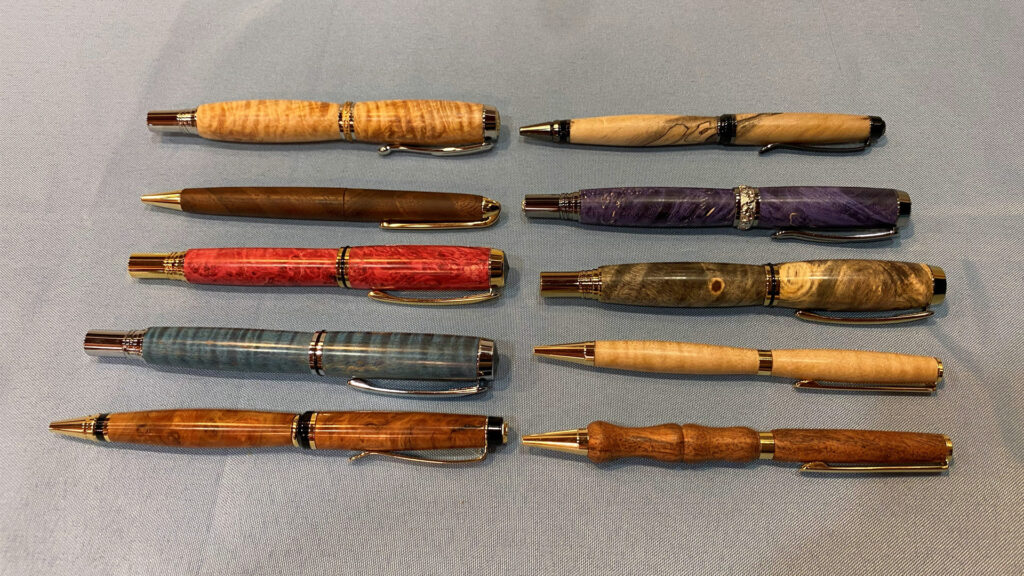 Ten handmade pens were turned from various species of wood by Tina.