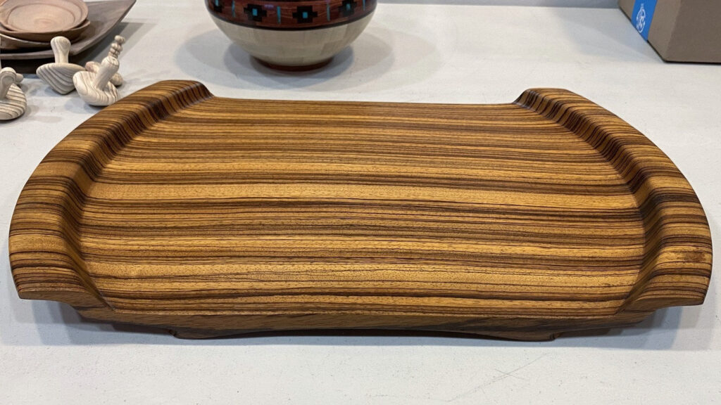 A striped zebrawood oval tray turned by Al Sills, displayed alongside other woodturning projects during the West Bay Woodturners Show & Tell.