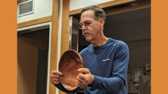 Kelly Smith shows a bowl he turned