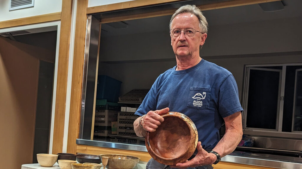 Tom Gaston shows a bowl he turned