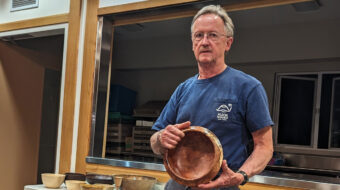 Tom Gaston shows a bowl he turned